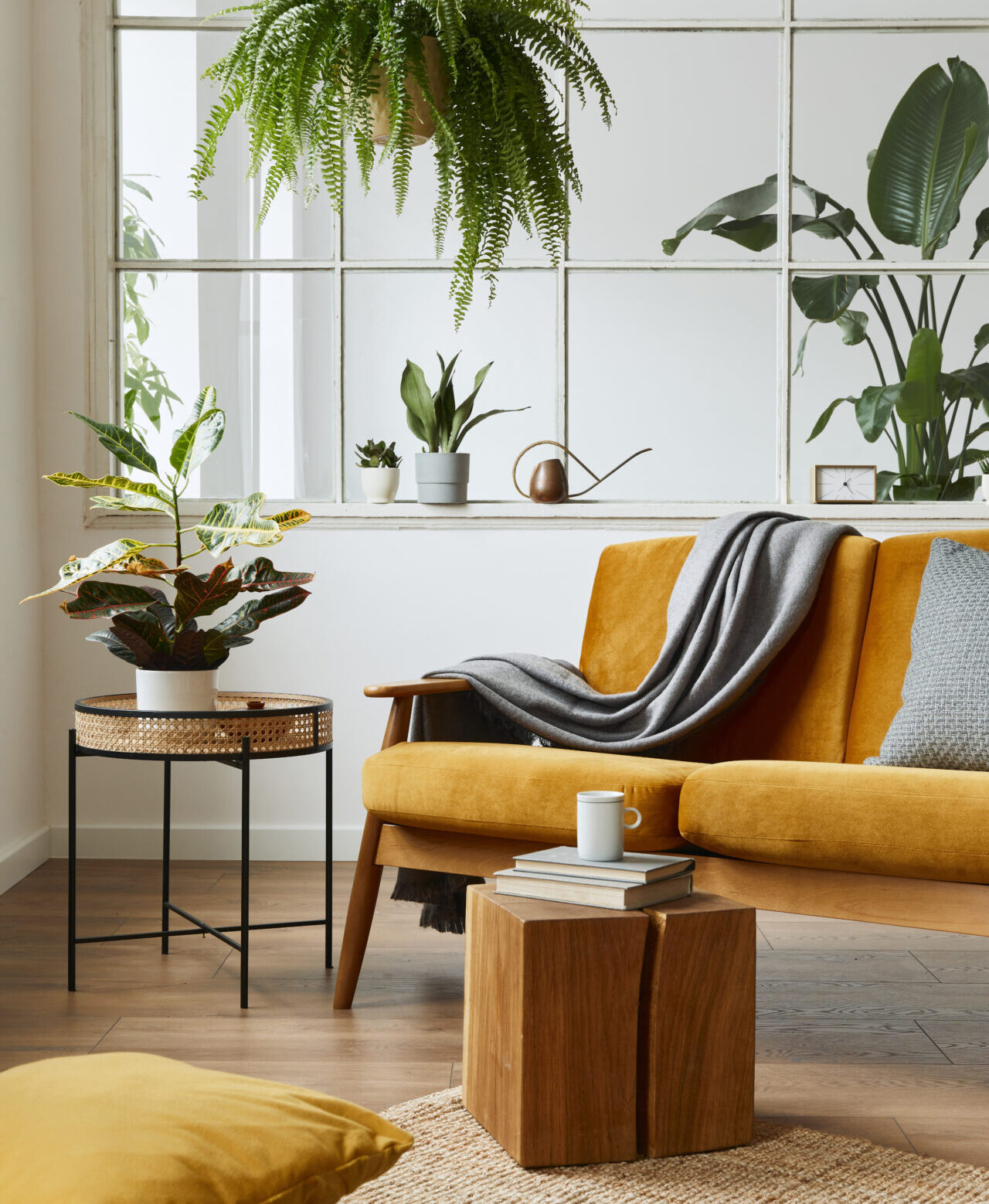 Living room with hardwood flooring, mustard yellow chair, plants, and modern decor